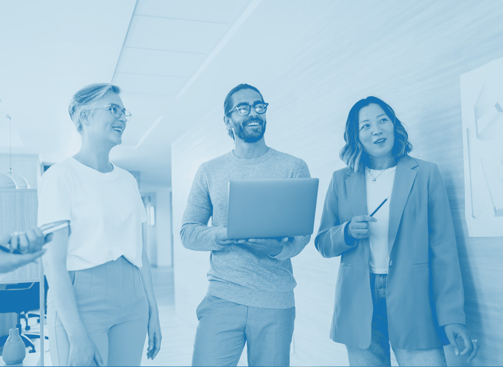 three office people stand and smile, laptop, man and woman, employee benefits